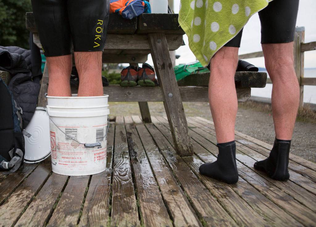 Joe Hempel (left) stands in a bucket of hot water to warm up as Brian McCleary dries off. (Olivia Vanni / The Herald)