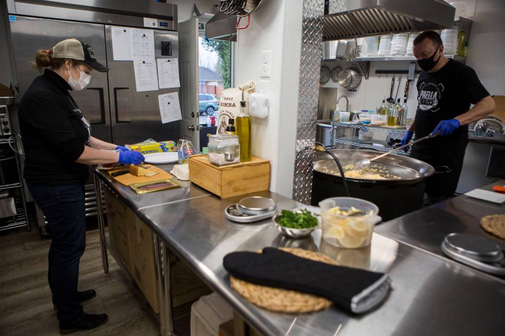 Laura and Greg McLaughlin work on to-go orders in the kitchen they built in their garage. (Olivia Vanni / The Herald)