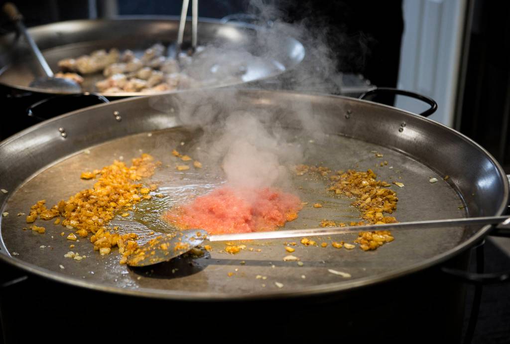 The McLaughlins start out a paella cook with onions and tomatoes. (Olivia Vanni / The Herald)