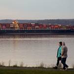 A couple walks in Harborview Park as the Seaspan Brilliance, a 1,105-foot cargo ship, is moored near the Port of Everett on Wednesday. (Andy Bronson / The Herald)