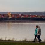 A couple walks in Harborview Park as the Seaspan Brilliance, a 1,105-foot cargo ship, is moored near the Port of Everett on Wednesday. (Andy Bronson / The Herald)