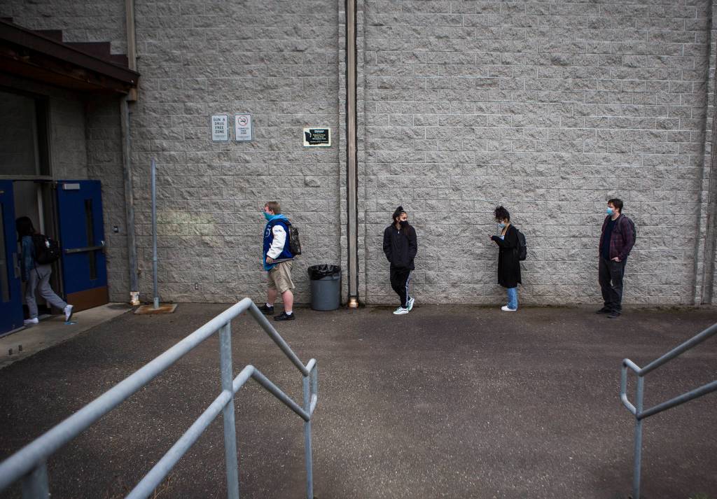 Students line up, social distanced, before entering Sultan High School on Thursday. (Olivia Vanni / The Herald)