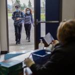 Students approach a checkpoint where they must fill out a wellness survey before having their temperatures checked at Sultan High School. (Olivia Vanni / The Herald)