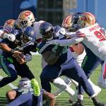 Seattle Seahawks quarterback Russell Wilson, left, is tackled as offensive guard Damien Lewis, right, blocks San Francisco 49ers defensive end Arik Armstead (91) during the first half of an NFL football game, Sunday, Nov. 1, 2020, in Seattle. (AP Photo/Elaine Thompson)