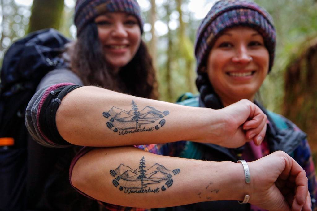 Colleen Fadden (left) and Kendra Swanson recently got matching tattoos to celebrate meeting their 100-hike goal in 2020. (Kevin Clark / The Herald)