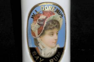 Silly as it may seem, milk glass can be one of many colors. It is an opaque glass first used in the 1800s and now prized in collections of barber bottles of the Victorian era. This 10½-inch-high milk glass barber bottle with a colorful label under glass sold for $200. (Cowles Syndicate Inc.)