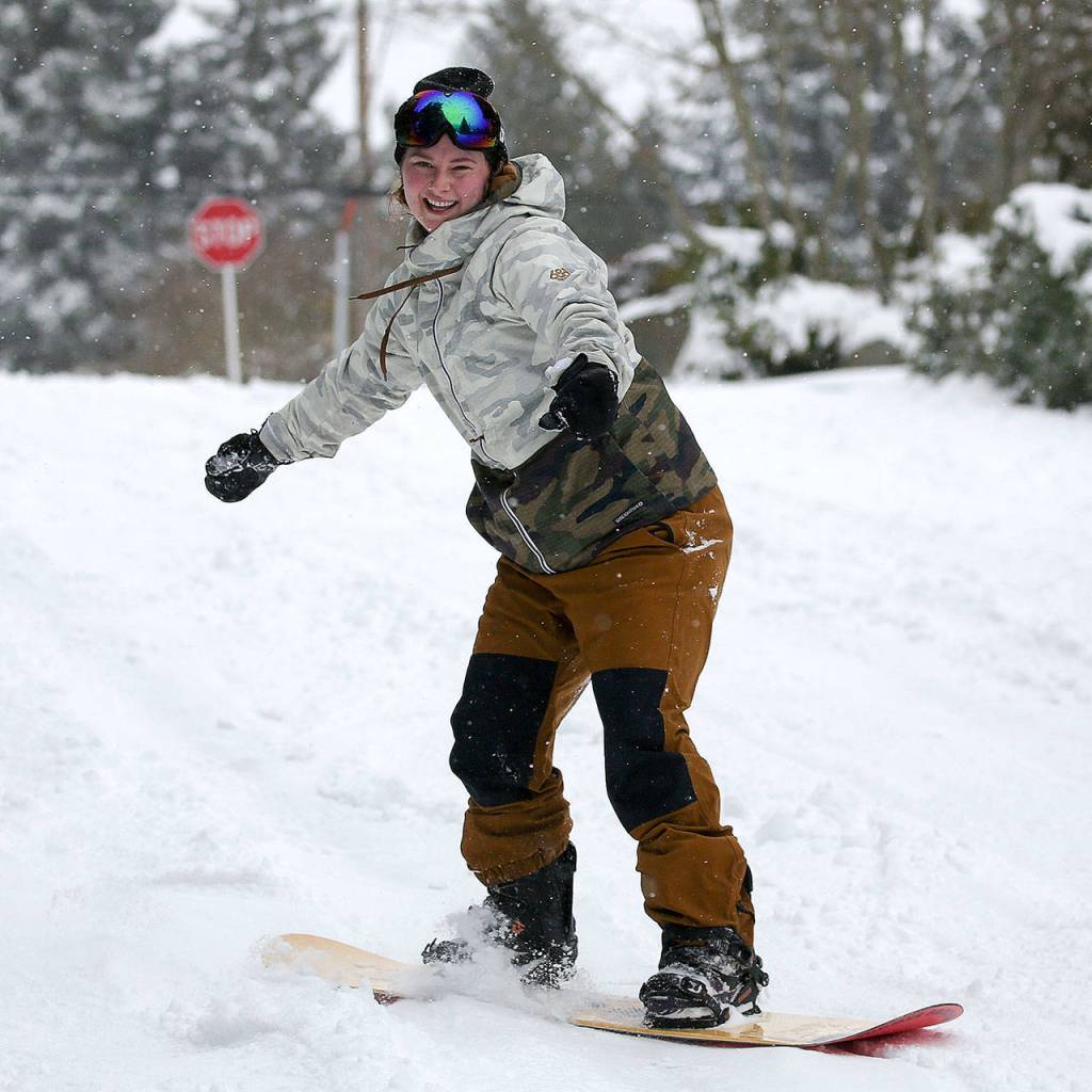 Kyla Sumpter makes her way down snow-covered streets Saturday in Edmonds. (Kevin Clark / The Herald)