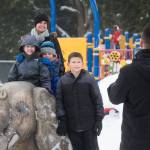 After sledding at Forest Park, John Toro takes a family photo of his wife, Suzette, and kids Juliana, Giovanni and Valentino, as they pose with an elephant statue Monday in Everett. (Andy Bronson / The Herald)