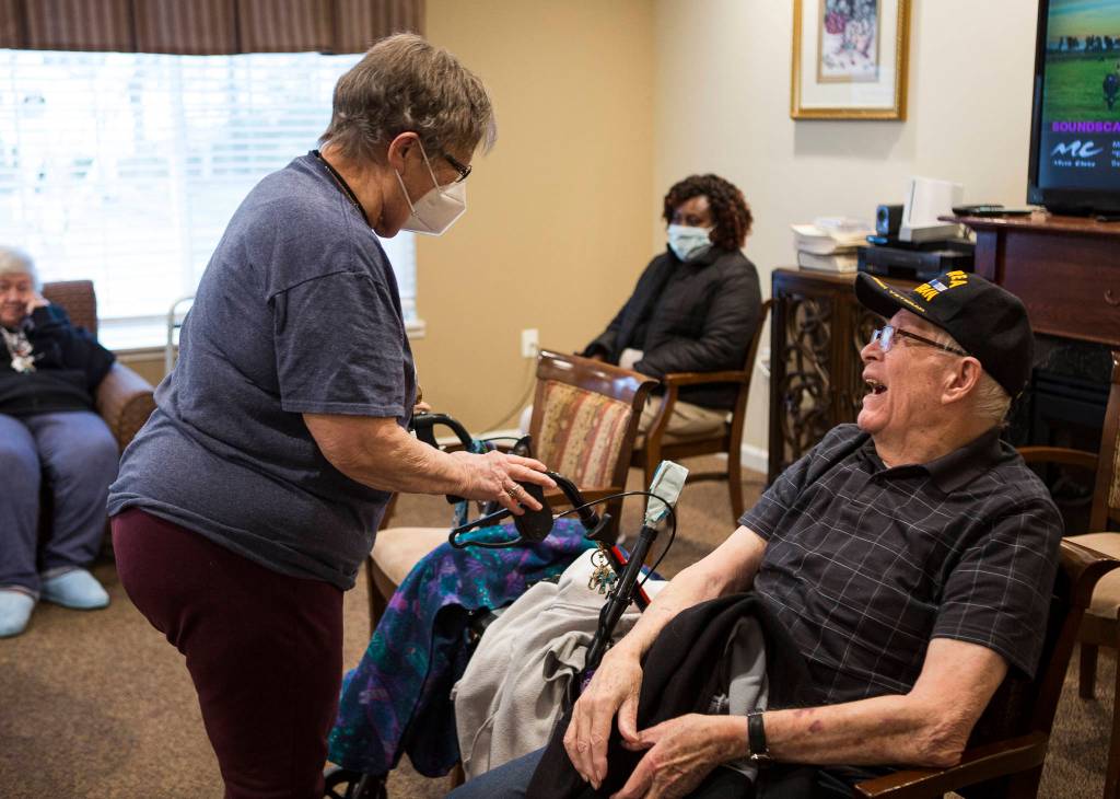 Rose Togerson (left) and Bob Wells (right) laugh together after receiving their Pfizer COVID019 vaccines Feb. 12 in Everett. (Olivia Vanni / The Herald)