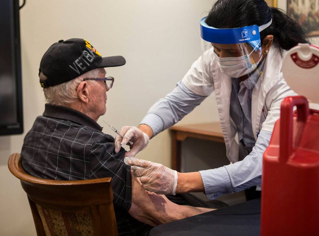 Walgreens Pharmacist Saradha Vedula preps Bob Well for his vaccine shot Feb. 12 in Everett. (Olivia Vanni / The Herald)