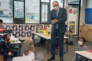 Washington Gov. Jay Inslee speaks with kindergartners in Chelsea Singh's class during a visit to Firgrove Elementary School in Puyallup, Wash., Thursday, Feb. 18, 2021. Students are back in school and all teachers and students are wearing masks. (Ellen M. Banner/The Seattle Times via AP, Pool)