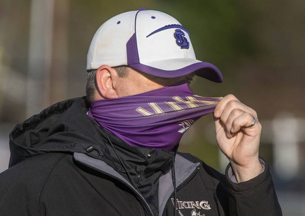 Head Coach Tom Tri pulls on his mask as he yells to his players as he Lake Stevens High School football team conducts its first practice Monday. (Andy Bronson / The Herald)