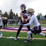 Quarterback Tanner Jellison runs a play with running backs Jay Roughton, left, and Trayce Hanks as the Lake Stevens High School football team conducts its first practice, marking the first day of practice for fall sports in the Wesco division, on Monday, Feb. 22, 2021 in Lake Stevens, Washington.  (Andy Bronson / The Herald)