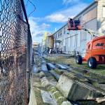 A worker on Tuesday covers windows with boards on the back side of the Mukilteo Research Station that will be torn down and not be rebuilt. (Andrea Brown / The Herald)