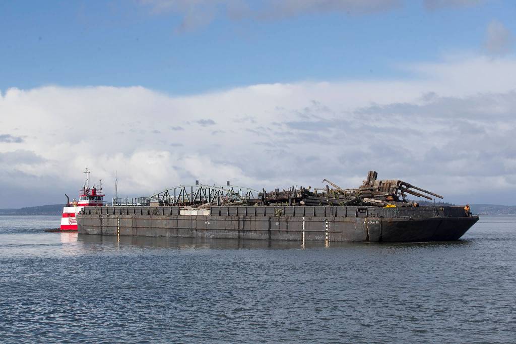 The tug Gladys M carries off the remains of the Mukilteo ferry dock ramp and pier Tuesday. (Andy Bronson / The Herald)
