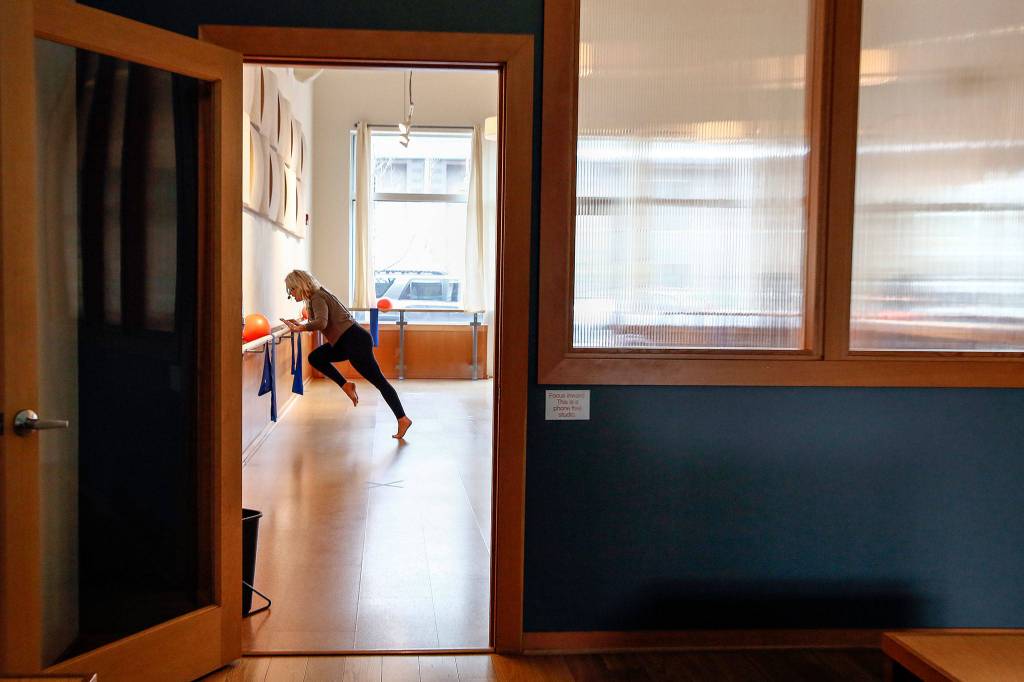 Tawni Dillon leads a virtual class from the Barre3 Mill Creek studio. (Kevin Clark / The Herald)
