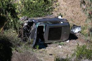 A vehicle rests on its side after a rollover accident involving golfer Tiger Woods along a road in the Rancho Palos Verdes suburb of Los Angeles on Tuesday, Feb. 23, 2021. Woods suffered leg injuries in the one-car accident and was undergoing surgery, authorities and his manager said. (AP Photo/Ringo H.W. Chiu)