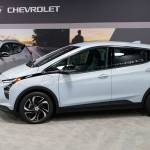 The 2022 Bolt EV, foreground, and EUV are displayed, Thursday, Feb. 11, 2021, in Milford, Mich. Whether people want them or not, automakers are rolling out multiple new electric vehicle models as the auto industry responds to stricter pollution regulations worldwide and calls to reduce emissions to fight climate change.  (AP Photo/Carlos Osorio)