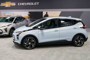 The 2022 Bolt EV, foreground, and EUV are displayed, Thursday, Feb. 11, 2021, in Milford, Mich. Whether people want them or not, automakers are rolling out multiple new electric vehicle models as the auto industry responds to stricter pollution regulations worldwide and calls to reduce emissions to fight climate change.  (AP Photo/Carlos Osorio)