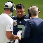 Seahawks coach Pete Carroll (right) talks to quarterback Russell Wilson (center) during the second half of a game against the Dolphins on Oct. 4, 2020, in Miami Gardens, Fla. (AP Photo/Wilfredo Lee)