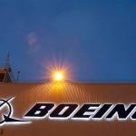 FILE- In this Oct. 19, 2015, file photo, an airplane flies over a sign at Boeing's newly expanded 737 delivery center at Boeing Field in Seattle. Federal regulators have imposed $5.4 million in civil penalties against Boeing on Thursday, Feb. 25, 2021, for violating terms of a $12 million settlement in 2015, and the aircraft maker has agreed to pay another $1.21 million to settle two current enforcement cases. (AP Photo/Ted S. Warren, File)
