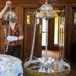 Renee Deierling attaches crystals to the reclaimed era chandelier Friday afternoon at the Carnegie Library in Snohomish. (Kevin Clark / The Herald)