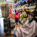 People browse wig and extension options while Decarla Stinn braids Hope Hottemdorfs hair. (Olivia Vanni / The Herald)