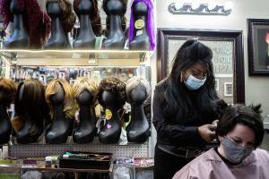 Decarla Stinn, owner of Decarla’s Beauty Supply & Salon in Everett, sews in the first row of extensions on Hope Hottemdorf on Wednesday, Feb. 24, 2021 in Everett, Wa. (Olivia Vanni / The Herald)