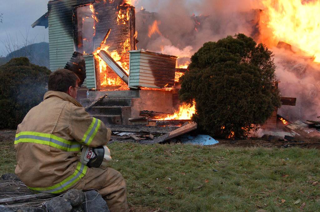 Isaac Howard watches a fire blaze during a training session with Snohomish County Fire District 26 in Gold Bar. (Bobby Lange)