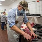 Kevin Ashe (right) and his daughter, Carly Nations, prep meat before opening time at the IGA in Darrington. (Olivia Vanni / The Herald)