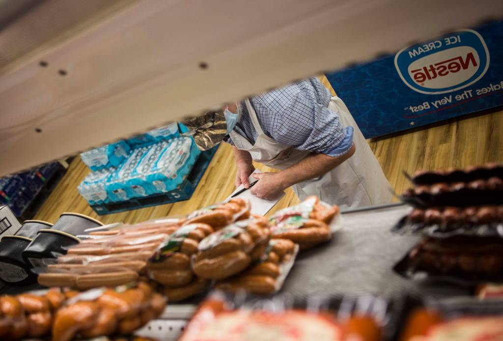Kevin Ashe inventories meat at the IGA in Darrington, which his family has owned for decades. (Olivia Vanni / The Herald)