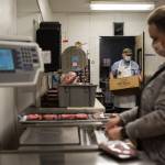 Kevin Ashe (left) and his daughter, Carly Nations, prep meat at the Darrington IGA. (Olivia Vanni / The Herald)