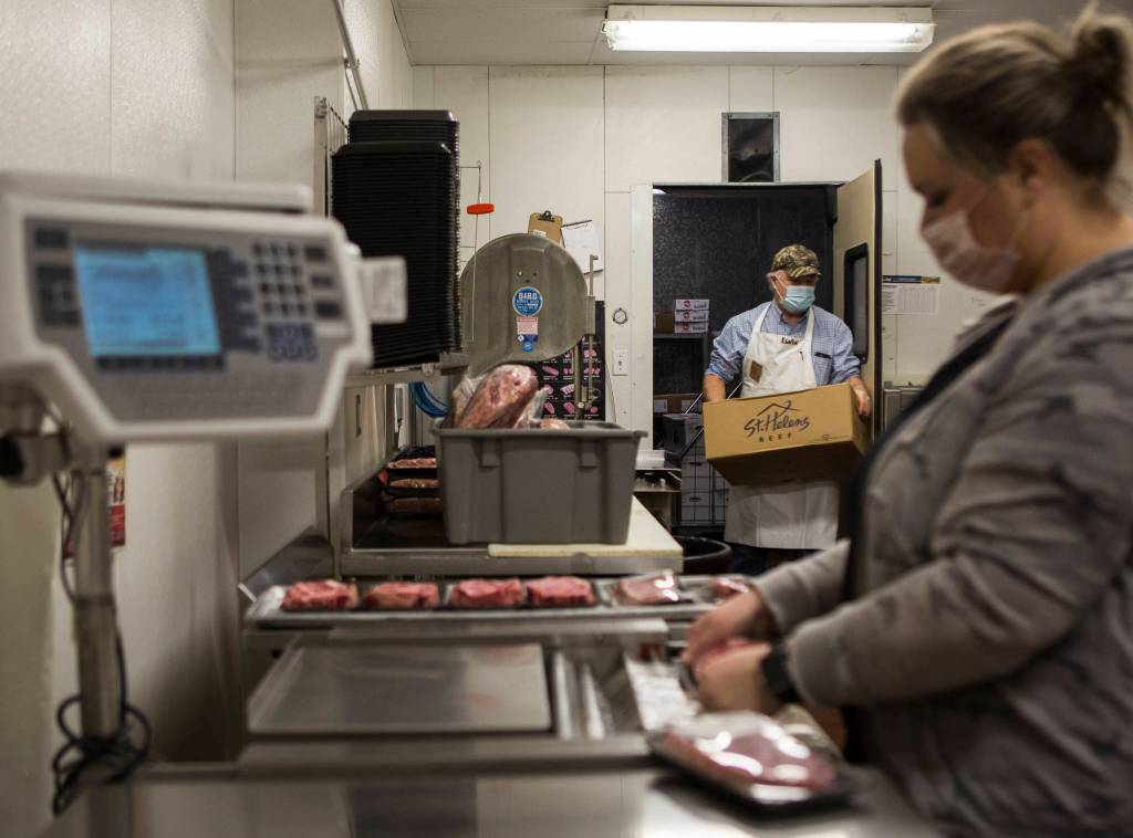 Kevin Ashe (left) and his daughter, Carly Nations, prep meat at the Darrington IGA. (Olivia Vanni / The Herald)