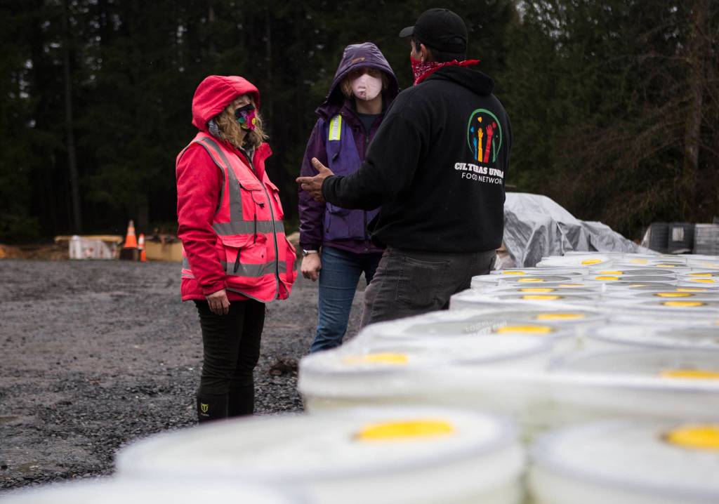 Farmer Frog founder Zsofia Pasztor and daughter Szabi Pastor chat with local Culturas Unidas Food Network driver and volunteer Fransisco Ramales on Friday in Woodinville. (Olivia Vanni / The Herald)