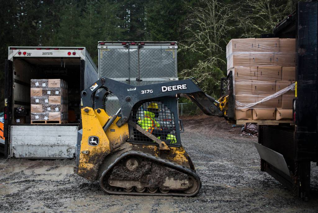 Farmer Frog staff loads food boxes into the back of a truck Friday in Woodinville. (Olivia Vanni / The Herald)