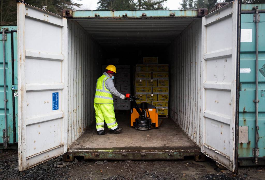 Farmer Frog staff unload pallets of food from containers Friday in Woodinville. (Olivia Vanni / The Herald)