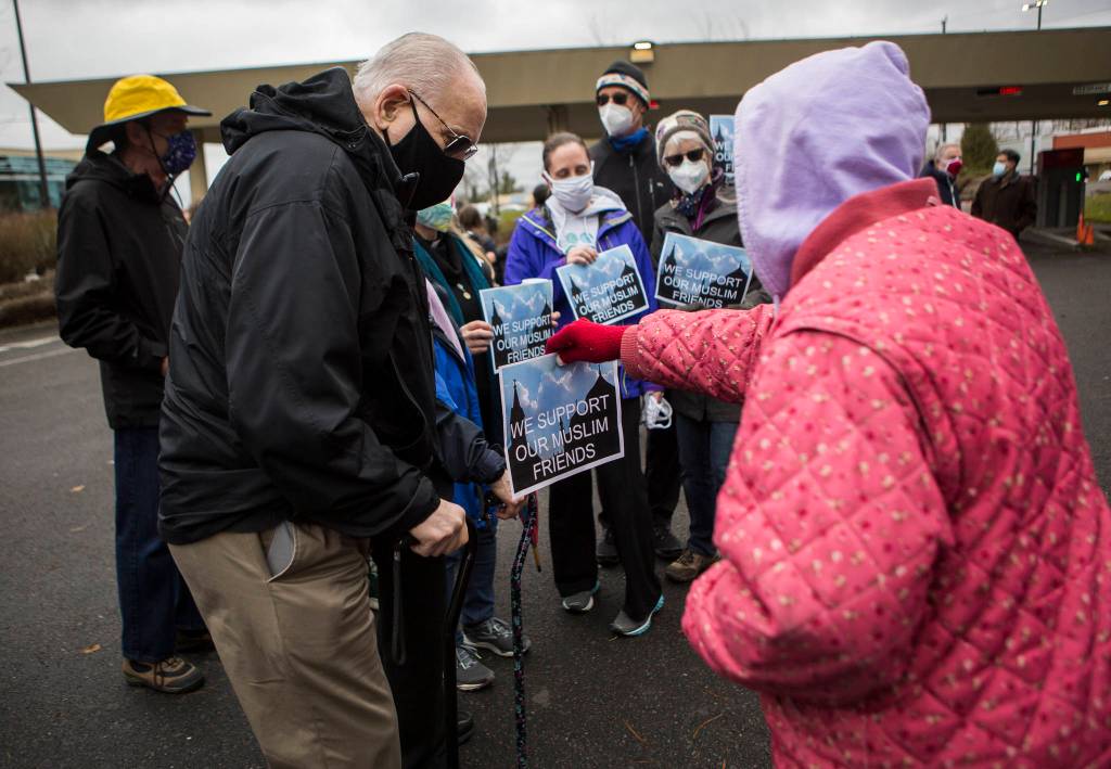 People hand out flyers in support at the groundbreaking ceremony for the Islamic Center of Mukilteo on Saturday. (Olivia Vanni / The Herald)