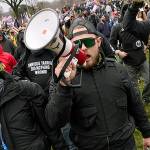 FILE - In this Wednesday, Jan. 6, 2021 file photo Ethan Nordean, with backward baseball hat and bullhorn, leads members of the far-right group Proud Boys in marching before the riot at the U.S. Capitol. Nordean, 30, of Auburn, Washington, has described himself as the sergeant-at-arms of the Seattle chapter of the Proud Boys. The Justice Department has charged him in U.S. District Court in Washington, D.C., with obstructing an official proceeding, aiding and abetting others who damaged federal property, and knowingly entering or remaining in a restricted building. He asked a judge Monday, Feb. 8, 2021, to release him from detention pending trial. (AP Photo/Carolyn Kaster,File)