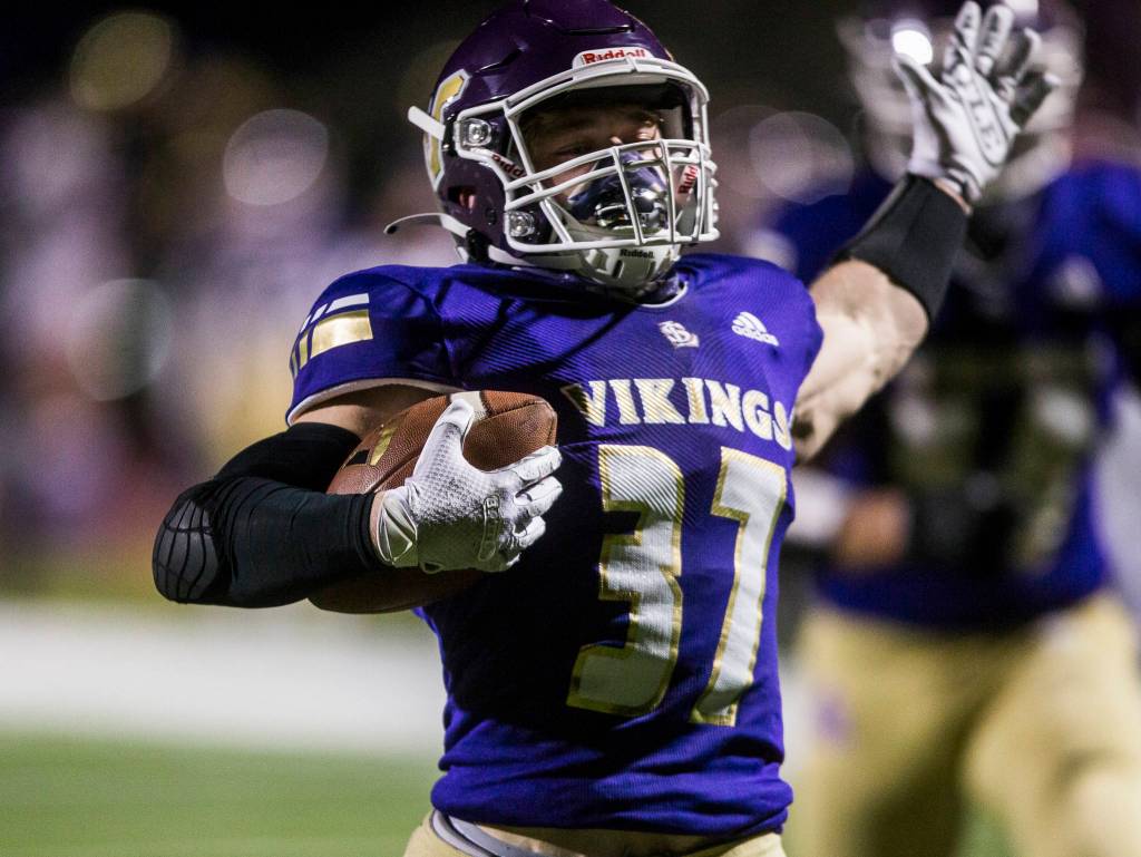 Lake Stevens Jay Roughton raises his arms as he runs in for one of his three touchdowns. (Olivia Vanni / The Herald)