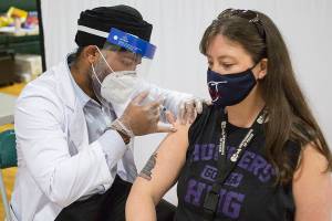 Alaina Livingston, a 4th grade teacher at Silver Furs Elementary, receives her Johnson & Johnson COVID-19 vaccine at a vaccination clinic for Everett School District teachers and staff at Evergreen Middle School on Saturday, March 6, 2021 in Everett, Wa. (Olivia Vanni / The Herald)