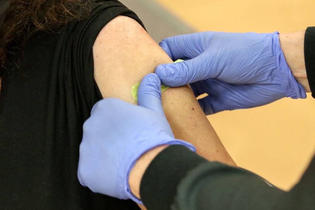 Berinda Wolitarsky, a teacher in Snohomish schools, gets a bandaid after her second vaccine shot Saturday morning at Snohomish High School. (Kevin Clark / The Herald)