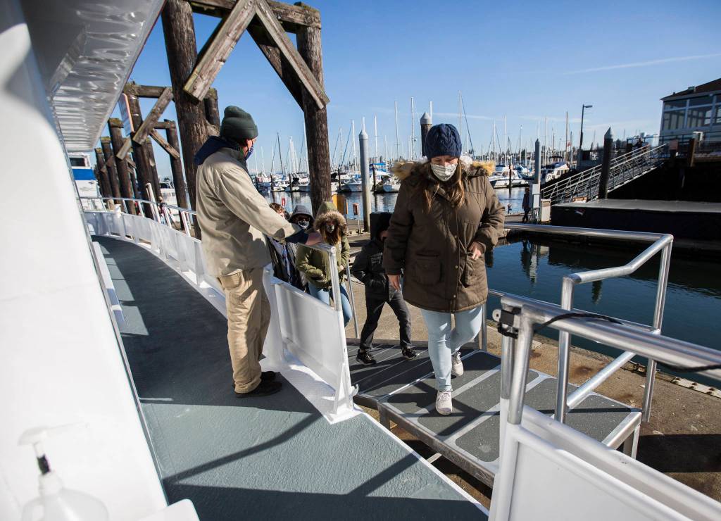 People board the Island Explorer 4 in Everett. Island Adventures Whale Watching is back in operation after closing for several months last year due to the coronavirus pandemic. (Olivia Vanni / The Herald)