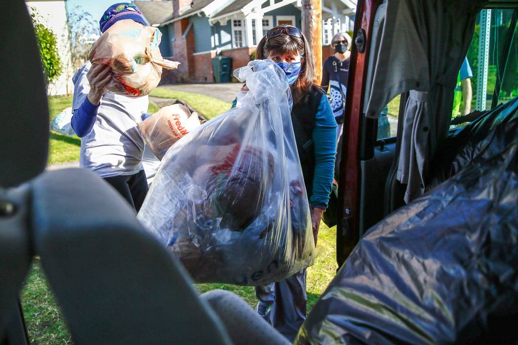 Stacie Douglas (right) loads her van with collected plastics Friday afternoon in Snohomish. (Kevin Clark / The Herald)