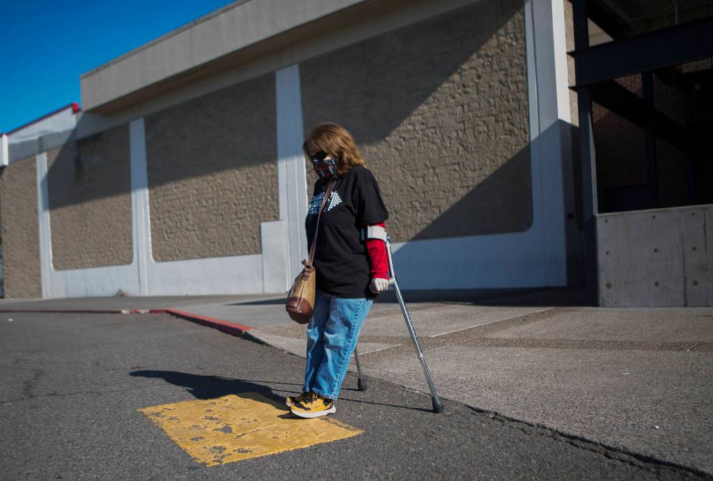 Leigh Spruce navigates the curb ramp cutouts and crosswalks at the Everett Mall. The city is developing an ADA transition plan that identifies access barriers in the right-of-way, such as curb ramps, pedestrian signals and sidewalks. (Olivia Vanni / The Herald)