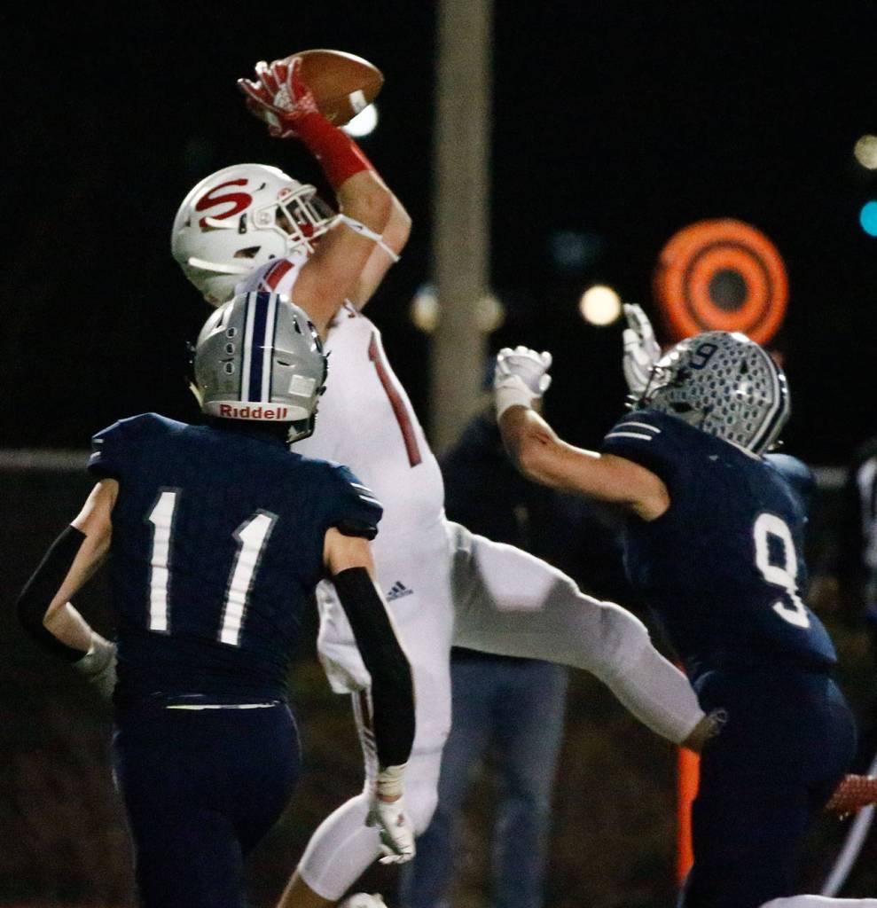 Snohomish's Kyden Gaffney makes a touchdown reception with Glacier Peak's Jadon Claps (left) and Ryan Kinney at Veterans Memorial Stadium Friday night in Snohomish on March 12, 2021. (Kevin Clark / The Herald)