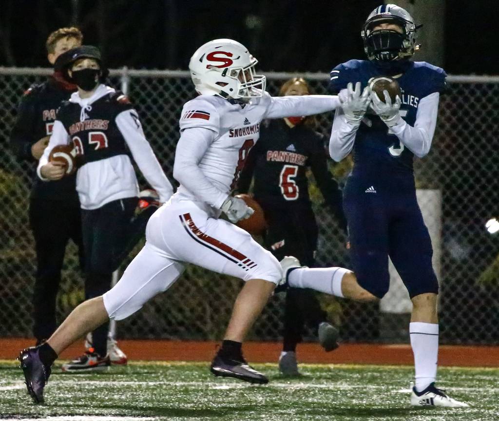 Glacier Peak's Matt Torgeson attempts a reception with Snohomish's Hunter Philabaum at Veterans Memorial Stadium Friday night in Snohomish on March 12, 2021. (Kevin Clark / The Herald)
