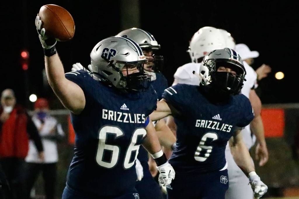 Glacier Peak's Adam Troxel celebrates a fumble recovery with teammate Jackson Hawkins at Veterans Memorial Stadium Friday night in Snohomish on March 12, 2021. (Kevin Clark / The Herald)