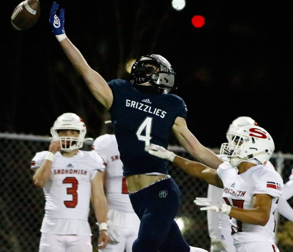 Glacier Peak's Cooper Jensen attempts a catch with Snohomish's Makai Williams defending at Veterans Memorial Stadium Friday night in Snohomish on March 12, 2021. (Kevin Clark / The Herald)