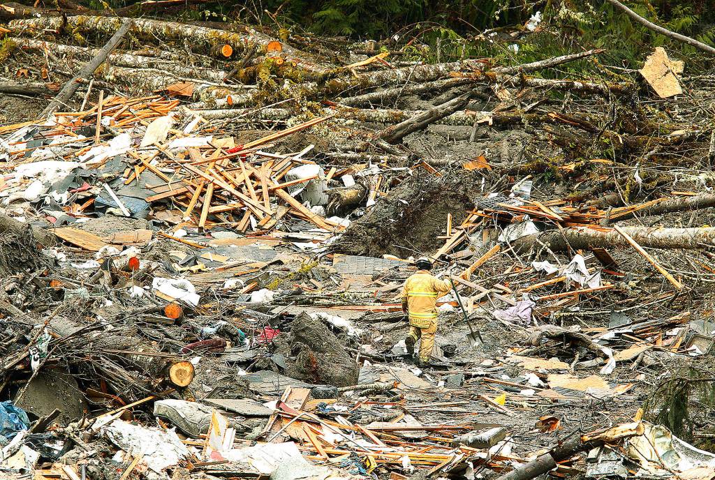 A firefighter searches debris five days after the Oso mudslide, on March 27, 2014. (Mark Mulligan / Herald file)
