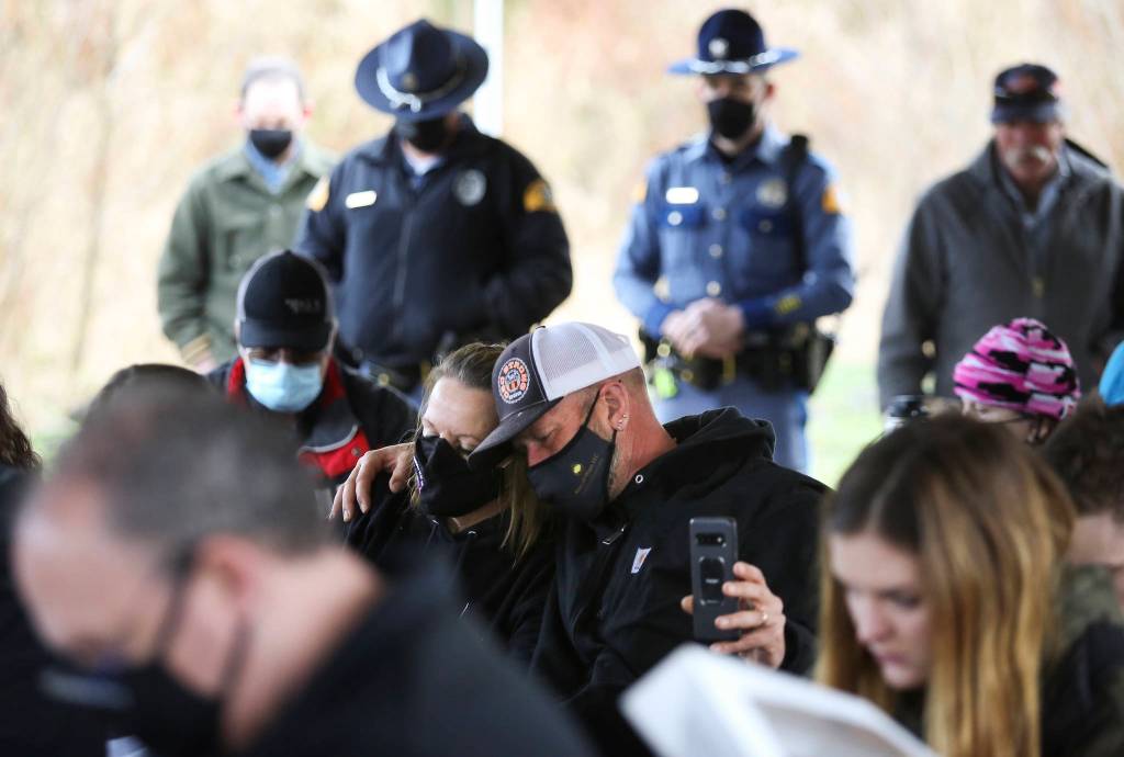 Nathan and Peggy Ray hug as they and others observe a minute of silence during a seventh anniversary memorial for those lost in the Oso landslide. (Andy Bronson / The Herald)